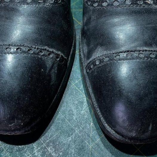 The scuffed toecaps of a pair of bespoke George Cleverley brogues, arriving at the Spitshine workshop for restoration