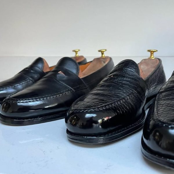 Two pairs of black loafers in calf and exotic leather, both finished to a high mirror shine by Spitshine