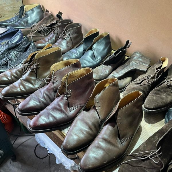 A row of clients' shoes lined up at the Spitshine workshop, in for cleaning, conditioning and repair